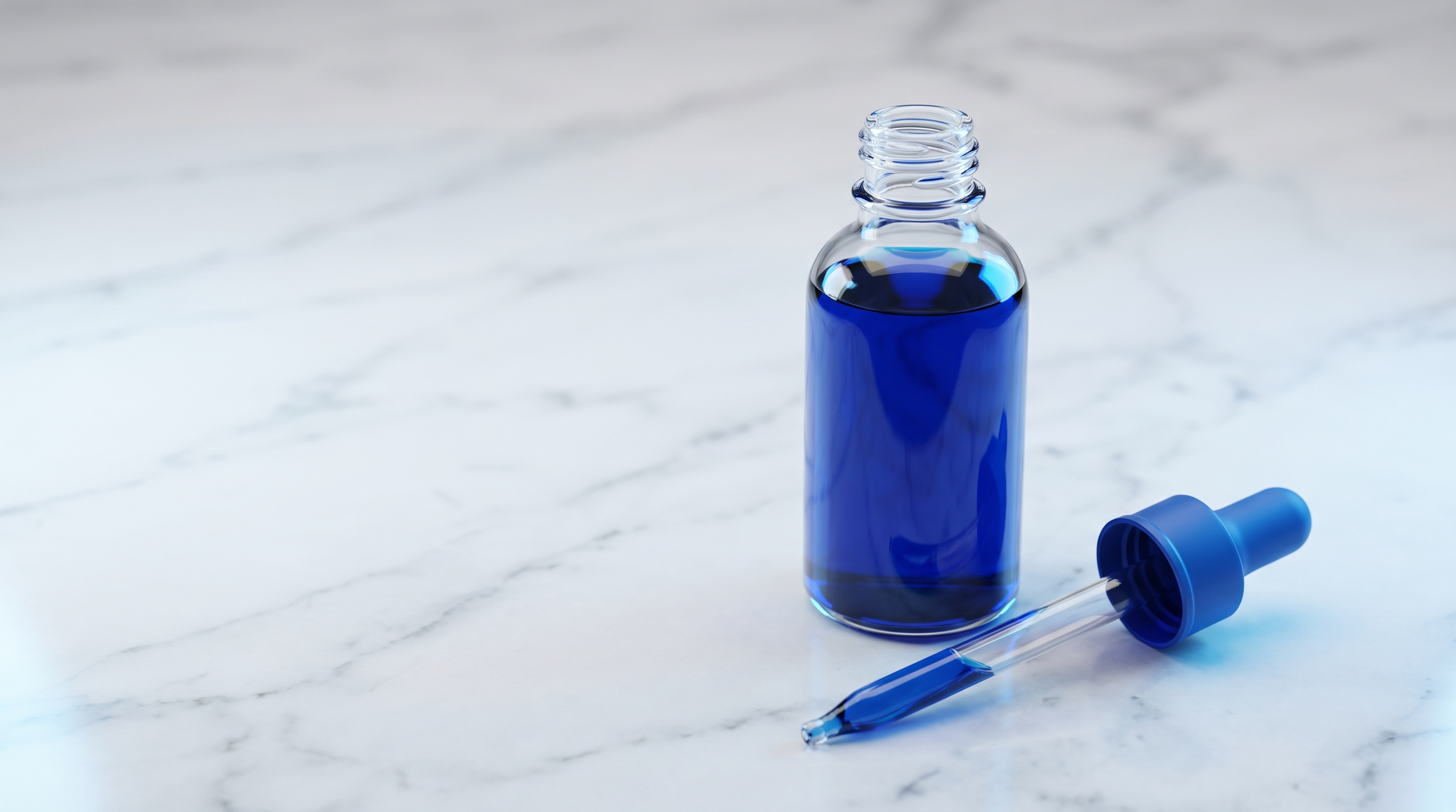 A glass dropper bottle of deep blue methylene blue liquid